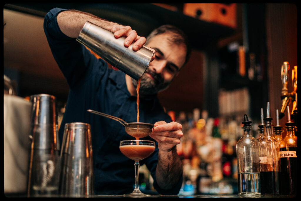 A bartender pouring a signature cocktail at Kissa Kissa | Jazz vinyl cocktail bar in Crown Heights, Brooklyn, New York City