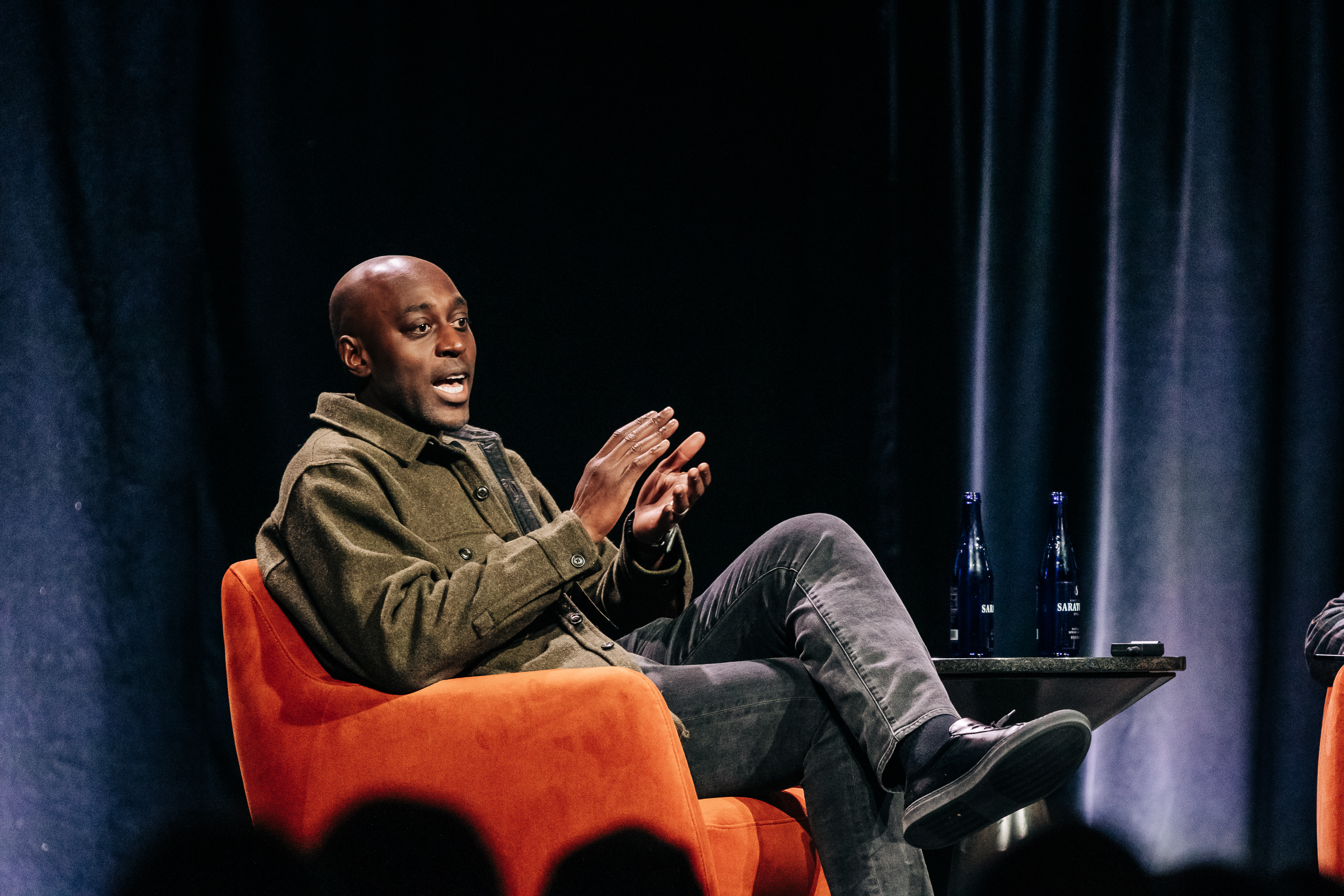 Wide-angle conference photography showing stage setup and engaged audience in Denver venue