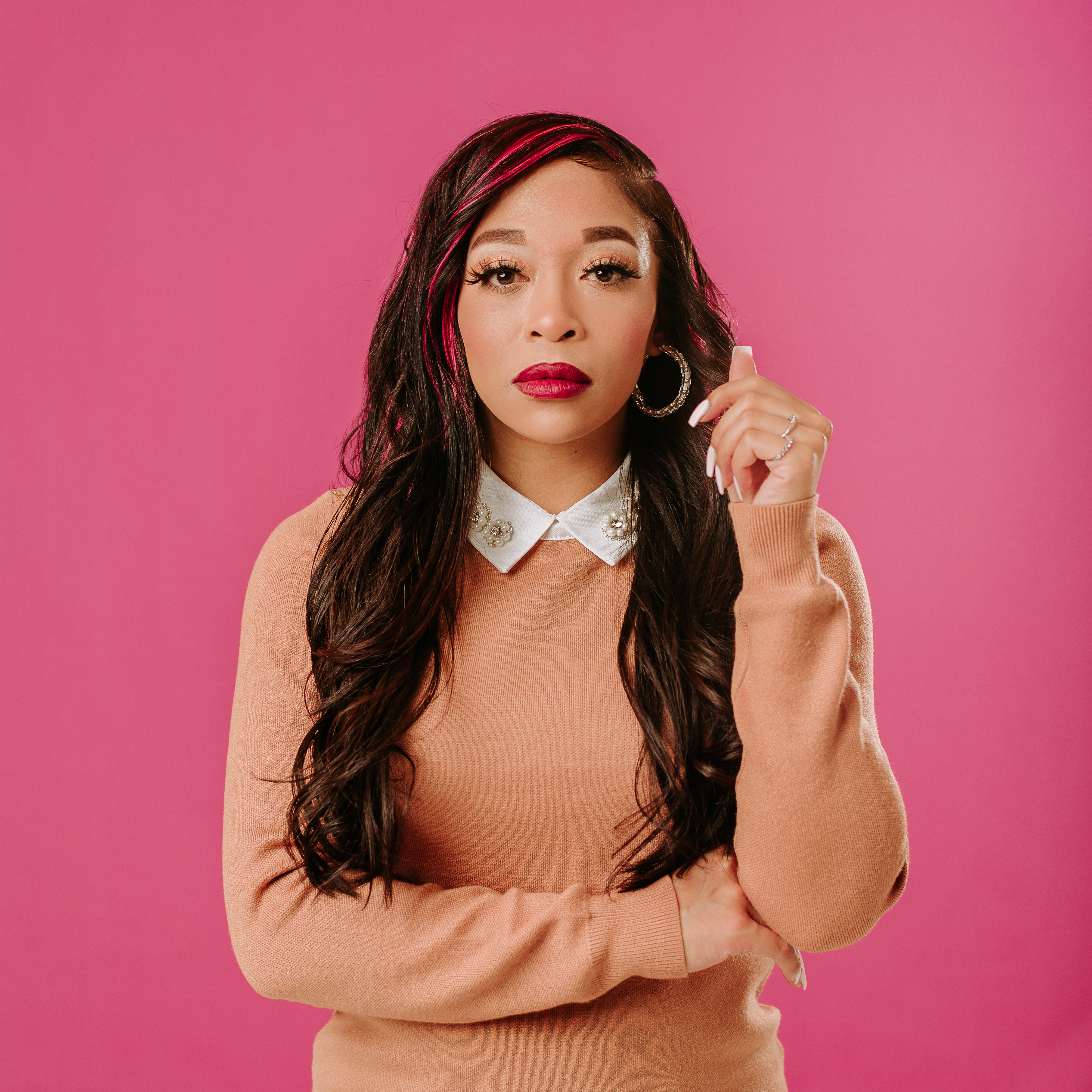 Musician smiling against a bright pink studio wall during a creative session at From the Hip Photo Studio Denver
