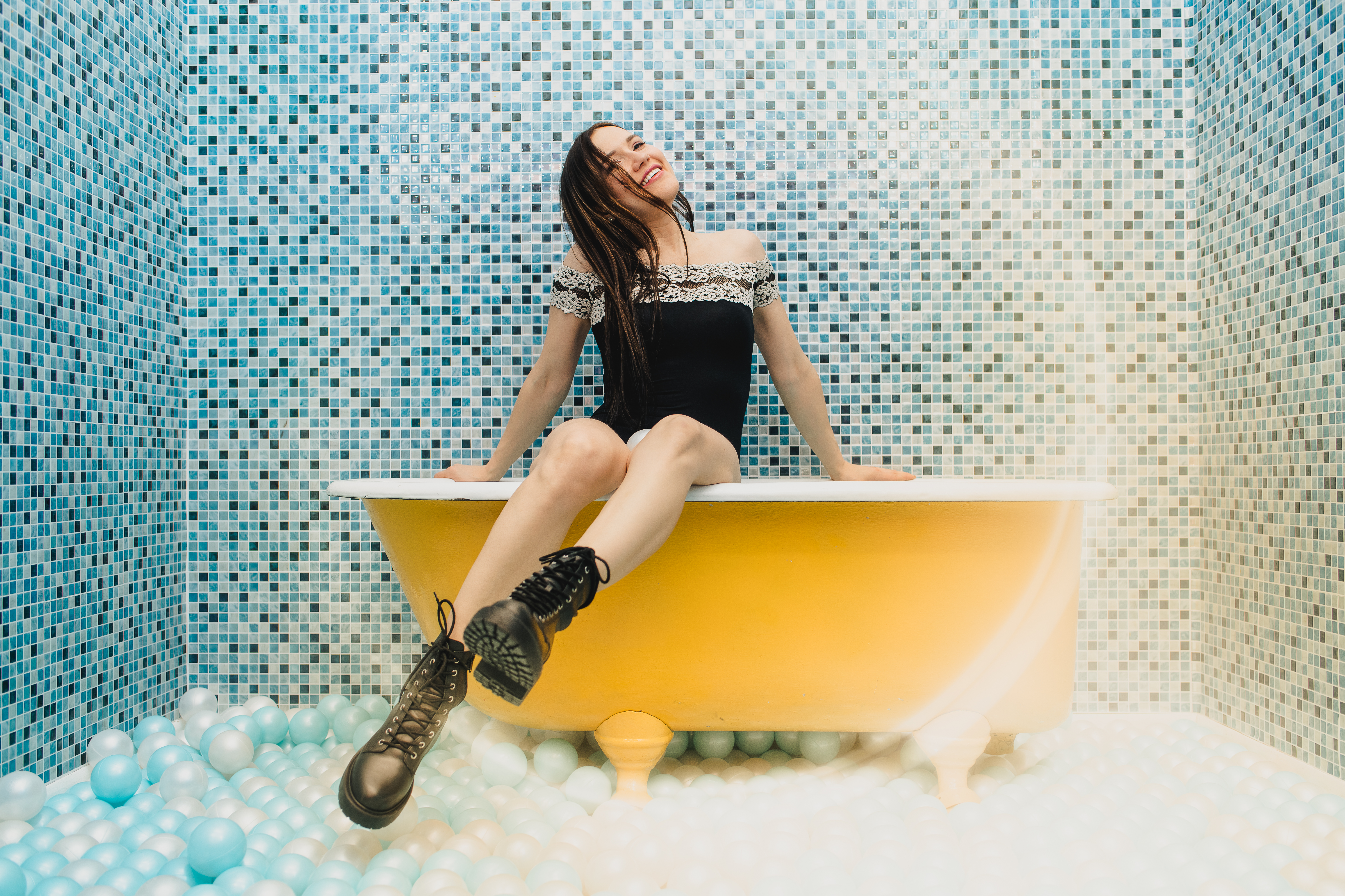 Fun creative portrait in a colorful ball pit bathtub installation at the Denver Selfie Museum