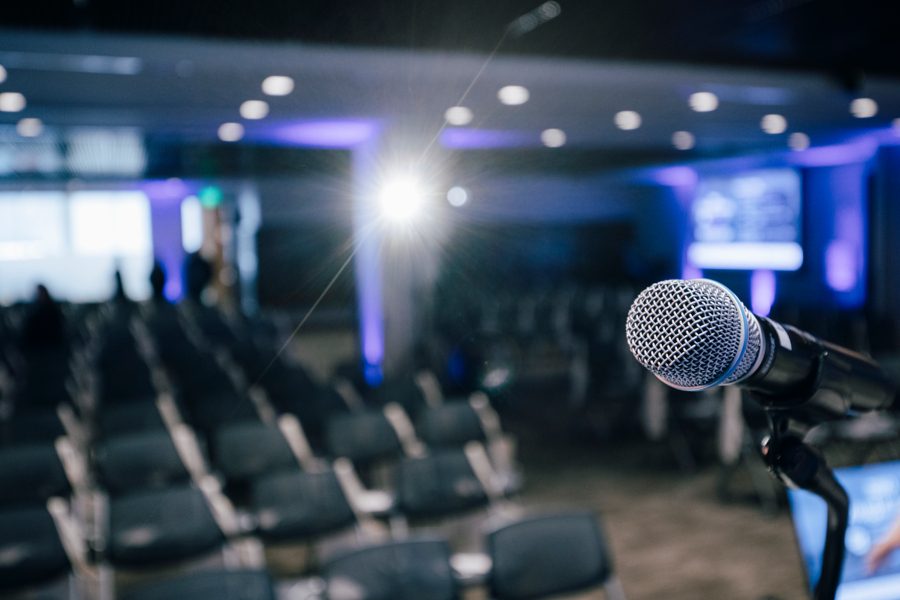 Conference speaker on stage with dynamic lighting at Denver event venue