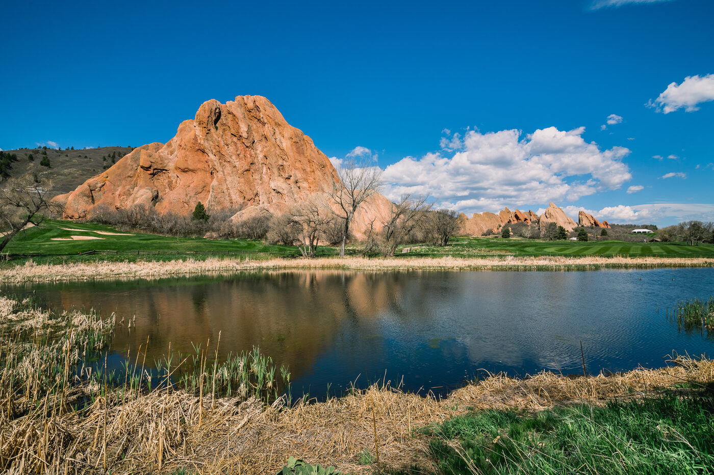 The red rock formations reflected in the water at Arrowhead Golf Club