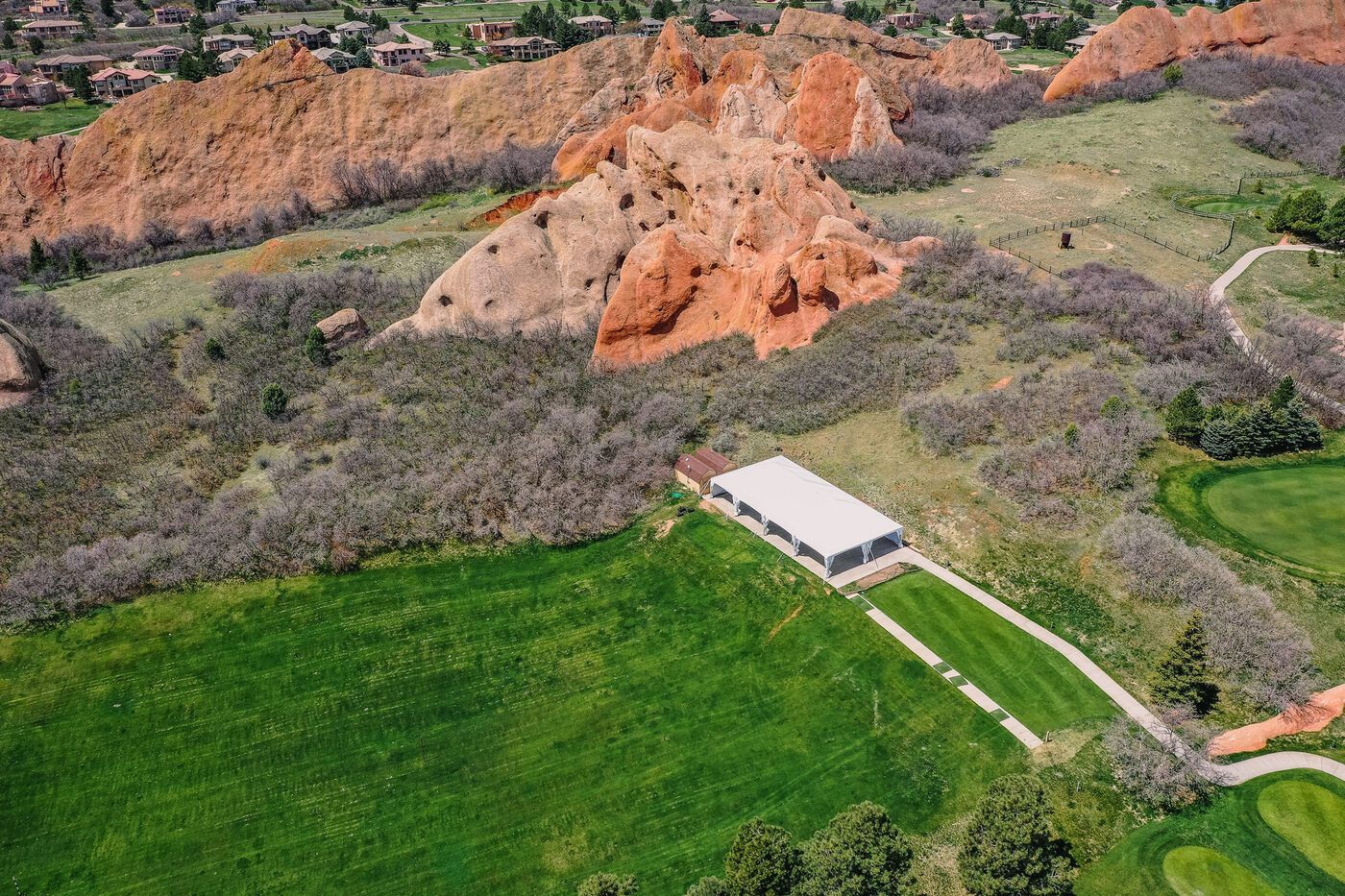 The tent pavilion on the lawn at Arrowhead Golf Club, framed by red rock formations